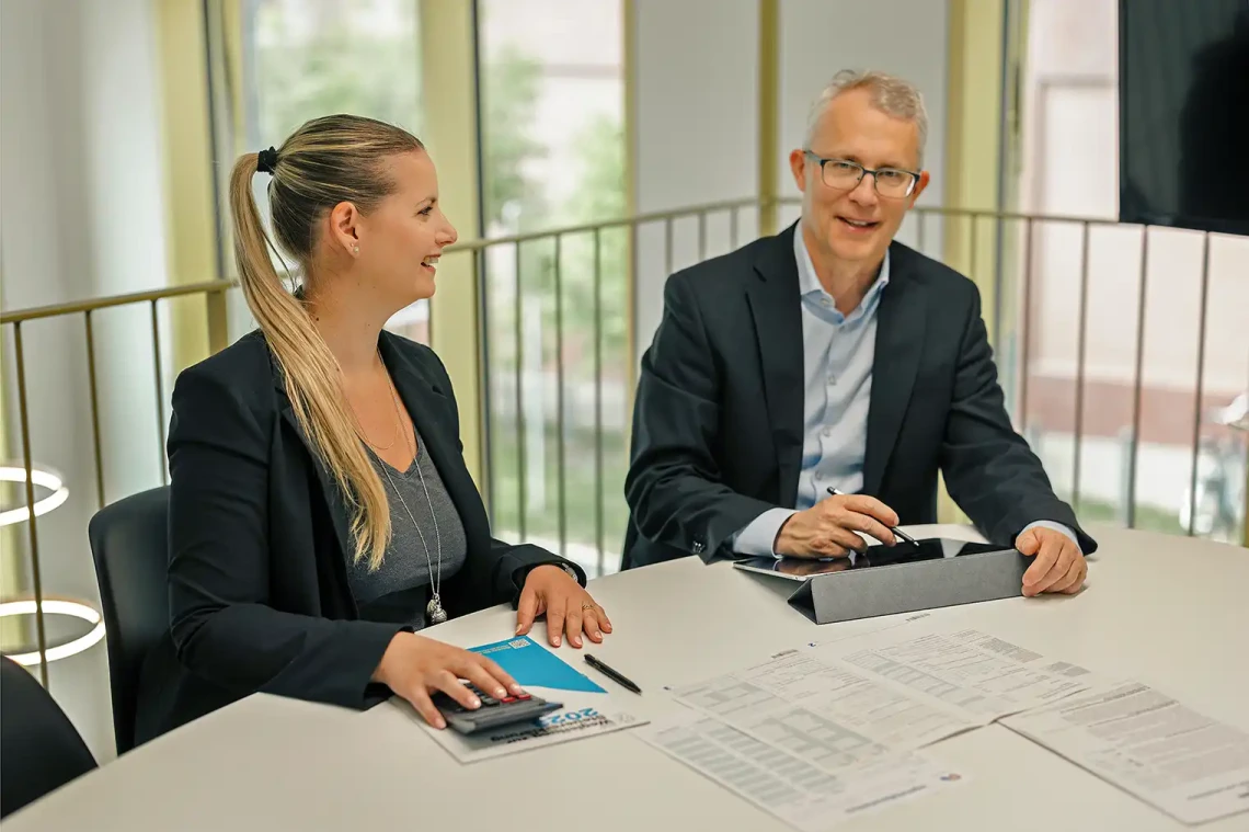 Foto zeigt Steueranwalt Rolf Benz und eine Mitarbeiterin bei der Arbeit.